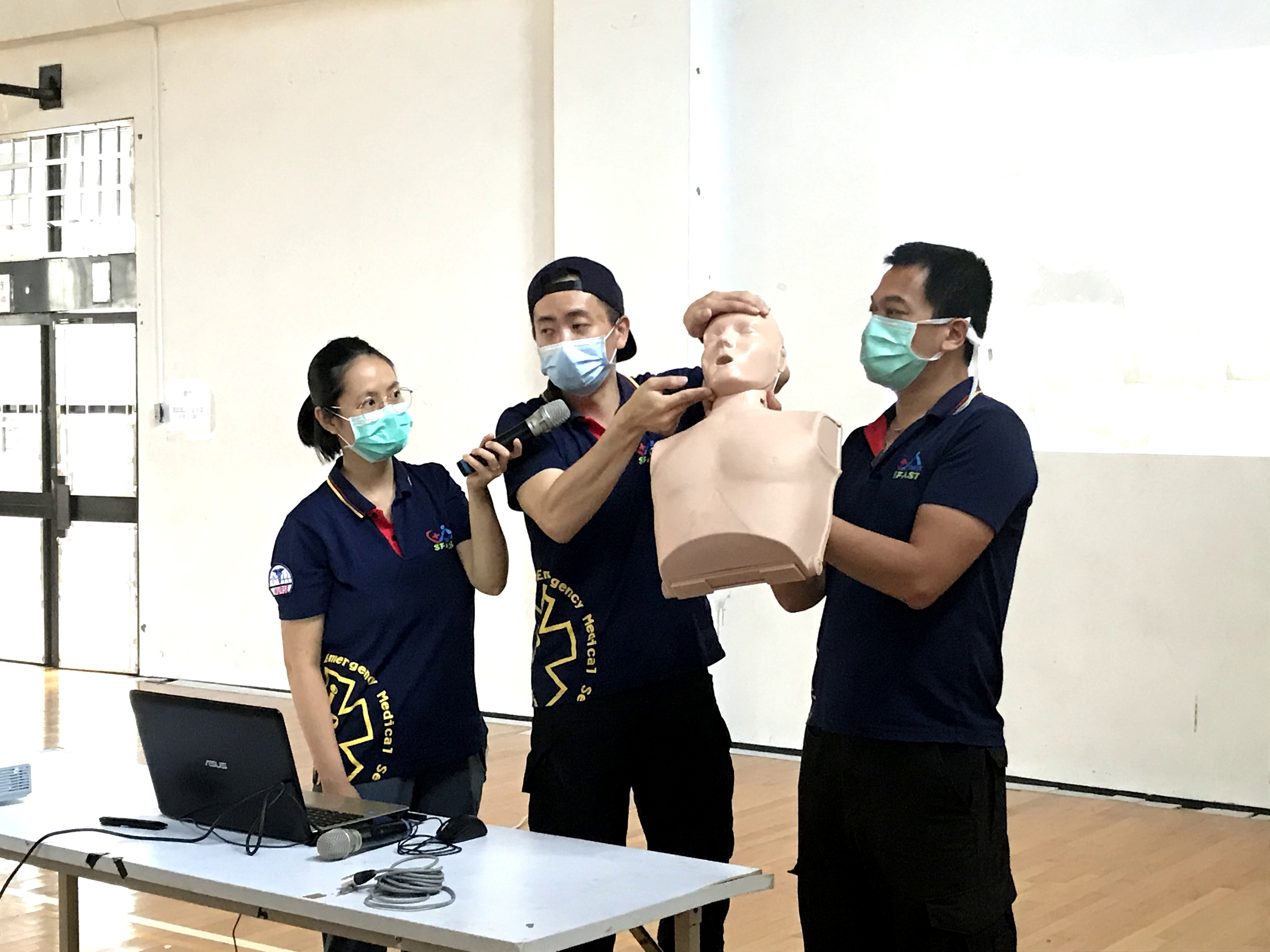 急救訓練教官及兩位助教用安妮示範如何暢通呼吸道