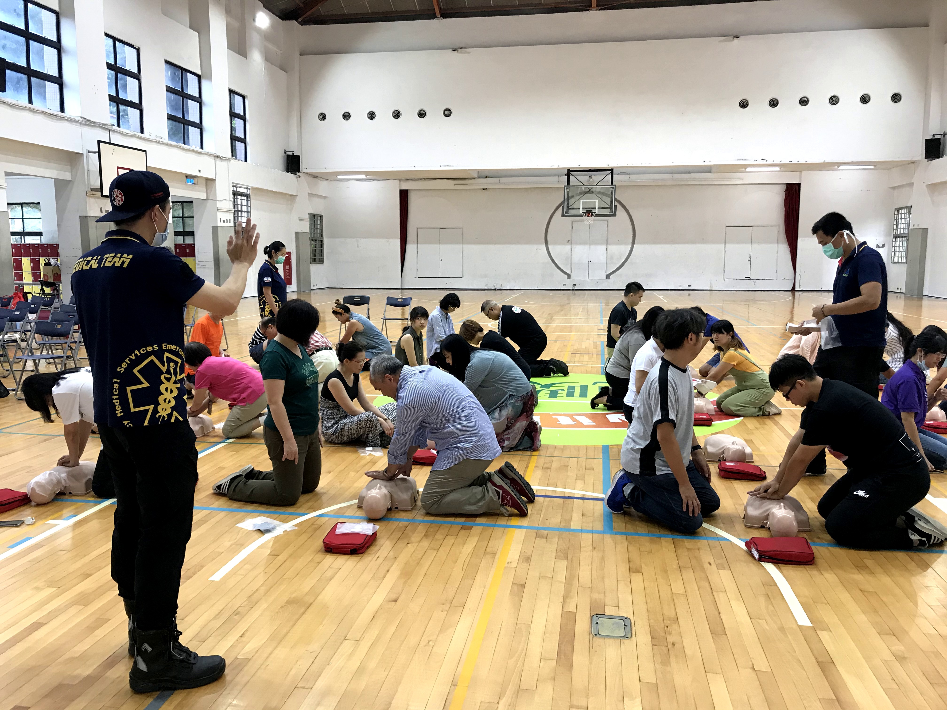 現場約20位教職員兩人一組練習CPR流程教官在旁協助